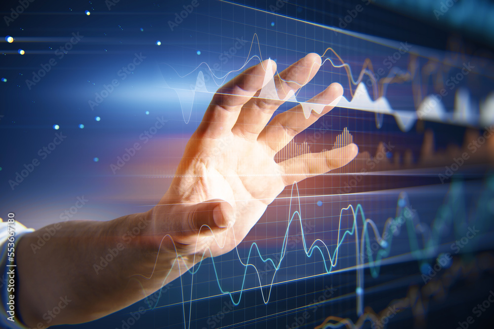 Close up of businessman hand using digital business graph hologram on blurry blue background. Trade, finance and analysis concept. Close up of businessman hand using digital business graph hologram on blurry blue background. Trade, finance and analysis concept.