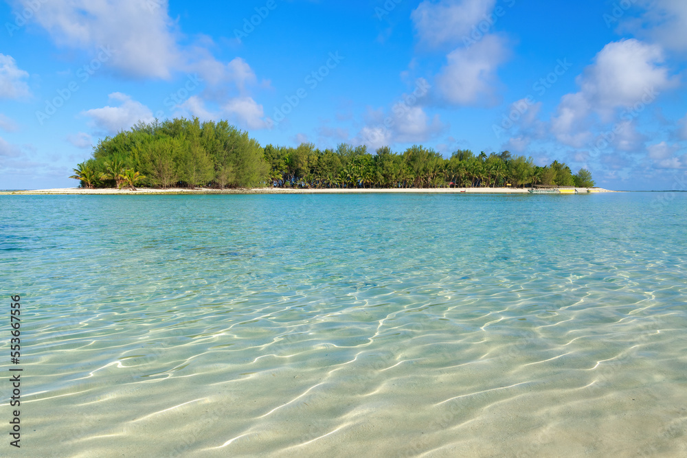 A small tropical island in the rippling waters of a shallow lagoon (Koromiri Island in Muri Lagoon, Rarotonga, Cook Islands) A small tropical island in the rippling waters of a shallow lagoon (Koromiri Island in Muri Lagoon, Rarotonga, Cook Islands)