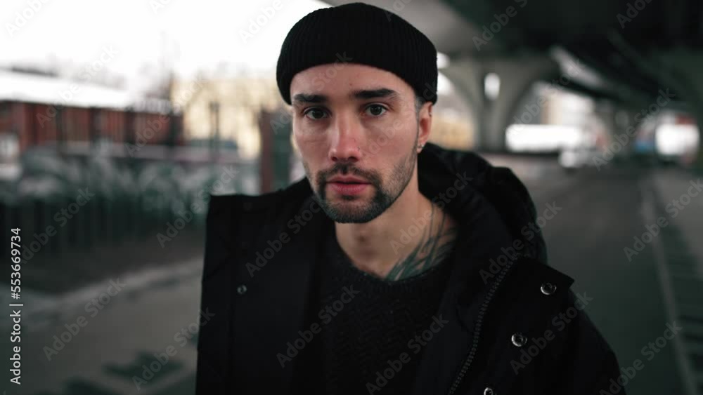 Brutal, fashionable, handsome and serious man with tattoo and beard walks under bridge or building on city street and looks at camera. Urban autumn walk. Healthy lifestyle in motion. Leisure activity. Brutal, fashionable, handsome and serious man with tattoo and beard walks under bridge or building on city street and looks at camera. Urban autumn walk. Healthy lifestyle in motion. Leisure activity.