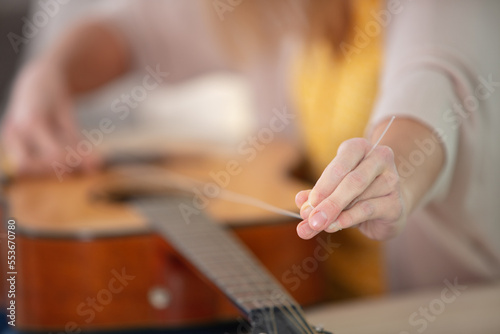 cropped image of woman changing guitar strings