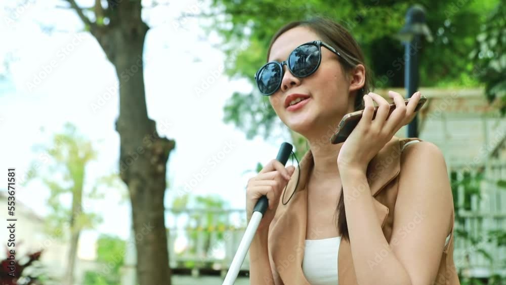 Beautiful blind Asian young woman in black glasses and holding cane sitting and talking with doctor in park, cheering, receives good news, eye treatment at hospital. Beautiful blind Asian young woman in black glasses and holding cane sitting and talking with doctor in park, cheering, receives good news, eye treatment at hospital.