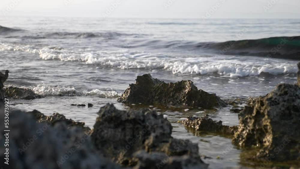 Waves breaking on the rocks. Etna volcano in the background. Beautiful landscape. Super slow motion Waves breaking on the rocks. Etna volcano in the background. Beautiful landscape. Super slow motion