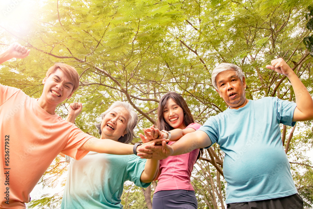 Fototapeta premium Happy asian family : Parents and sons and daughters join hands in exercising energy for healthy and happy minds in the park.