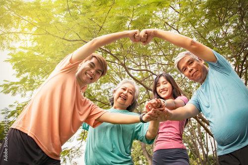 Happy asian family playing sports : Elderly parents and daughter son playing fusion in the garden together whole family greeting hilariously looking at camera : Happiness of retirees photo