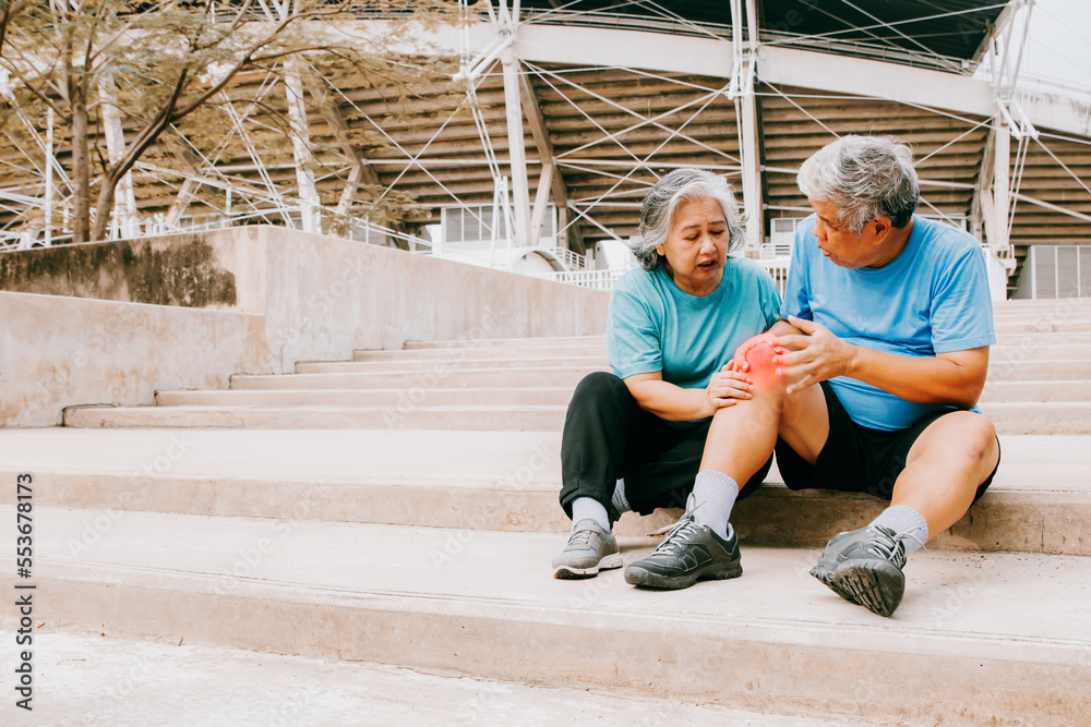 Elderly man with pain in his right knee during jogging on the hard