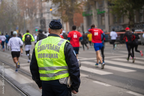 Belgrade, Serbia 27.11.2022 Police officer overwatching Runners that compete in race on Traditional Belgrade Marathon and Half Marathon on cold November day during Fog and high Air Pollution. 