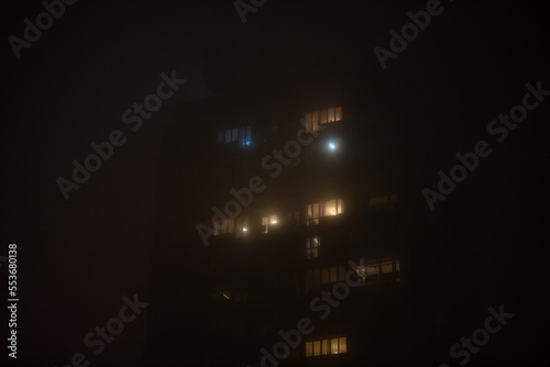 Smog lies over the residential building in Belgrade city at night. Poor visability, smog caused by air pollution. Emissions of plants and factories.