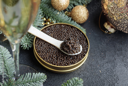 Black caviar in a mother-of-pearl spoon with Christmas decoration