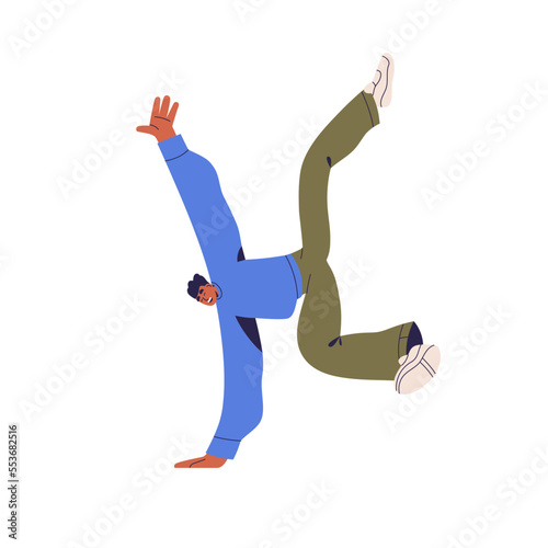 Happy young man in break dance movement on hand. Positive active person in fu...
