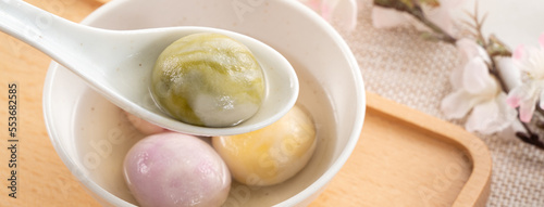 Colored glaze style big tangyuan with cherry blossom flower and syrup soup. photo
