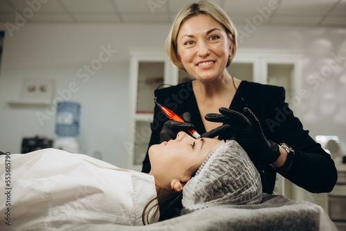 permanent master with tattoo machine in hand