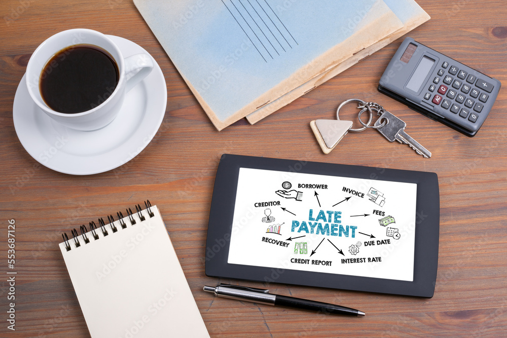 LATE PAYMENT. Illustration with keywords, icons and arrows. Tablet device on a wooden table LATE PAYMENT. Illustration with keywords, icons and arrows. Tablet device on a wooden table