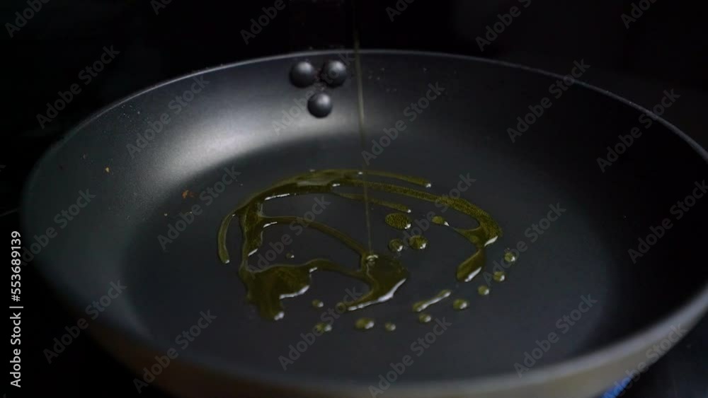 Echando aceite de oliva en sartén caliente