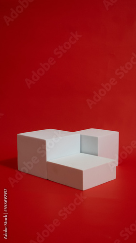 Realistic white cube pedestal podium set in red background. Minimal scene for product display presentation. Stage for showcase.