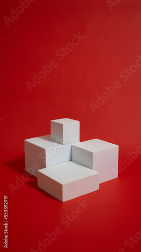 Realistic white cube pedestal podium set in red background. Minimal scene for product display presentation. Stage for showcase.