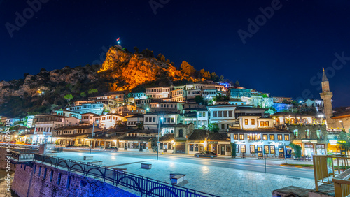 Evening view to Berat, historic city in the south of Albania at night with all lights flashing and white houses gathering on a hill. Captured during blue hour with the sky full of stars. photo
