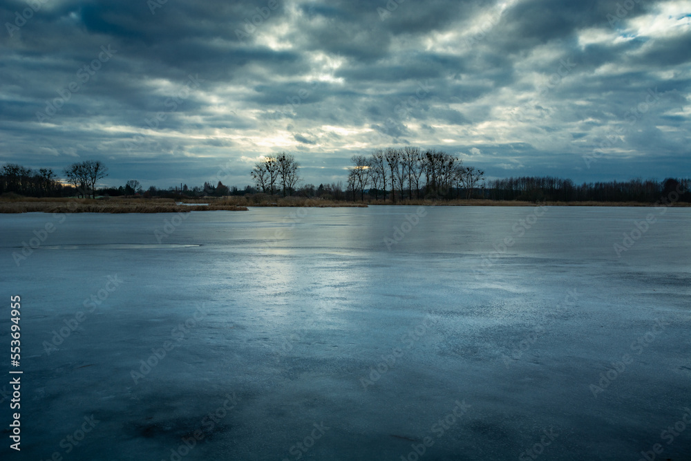 Evening view of a frozen lake and cloudy sky