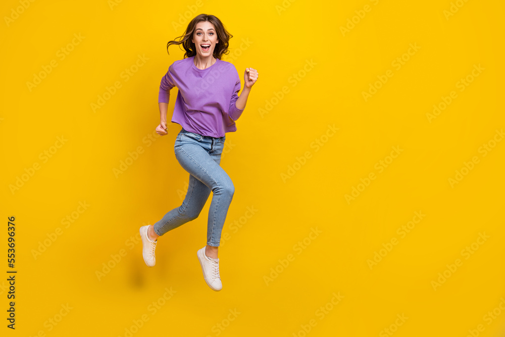 Full size photo of crazy carefree girl jumping running empty space isolated on yellow color background