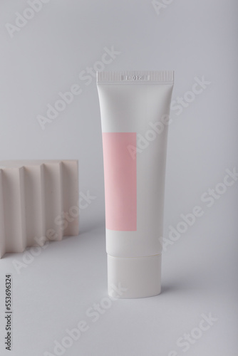 Wallpaper Mural Cream tube with pink blank label, no brand mockup on white background with geometric concrete decor. Tender minimal composition Torontodigital.ca