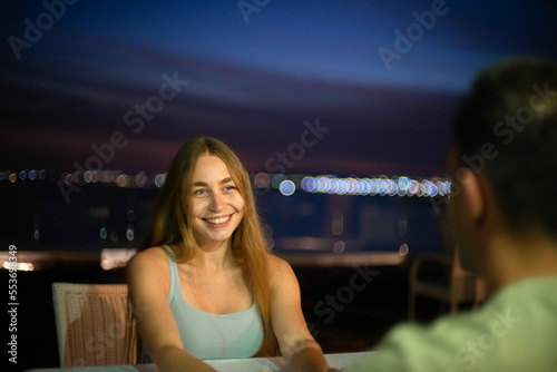 couple in love on a date at a table on the terrace in the evening on the sea. romantic date at the resort.