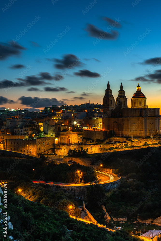 Il-Mellieha, Malta - illuminated Mellieha town at blue hour with Paris Church on hill top