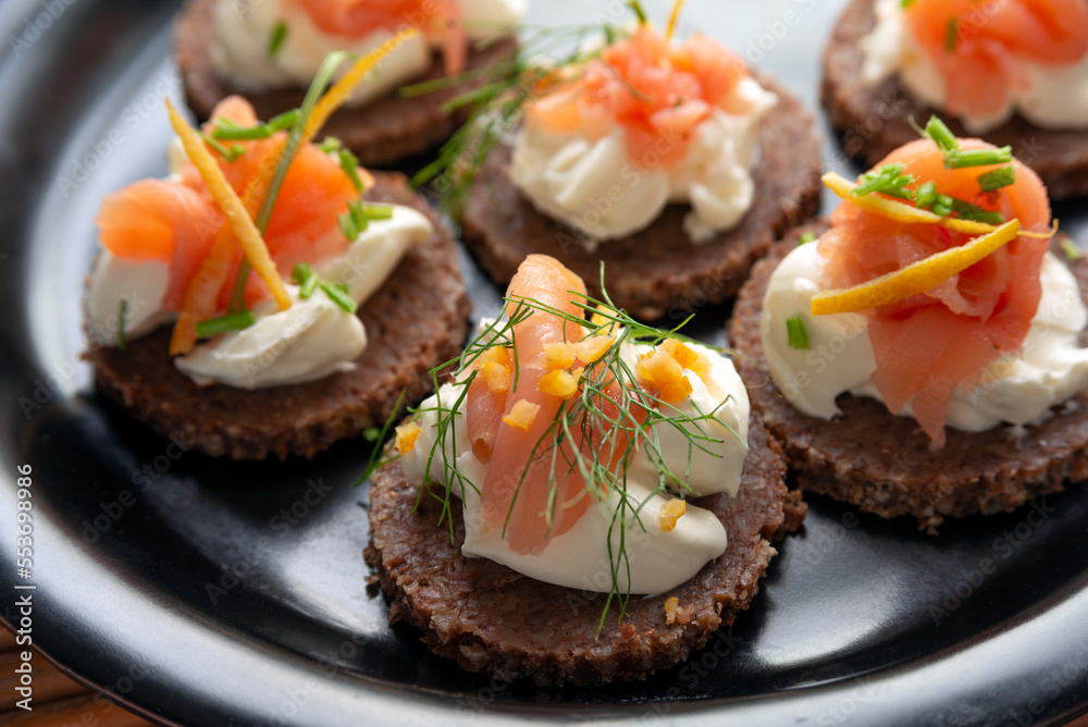 Deliziose canapes condite con crema di formaggio e salmone affumicato, antipasti europei Deliziose canapes condite con crema di formaggio e salmone affumicato, antipasti europei