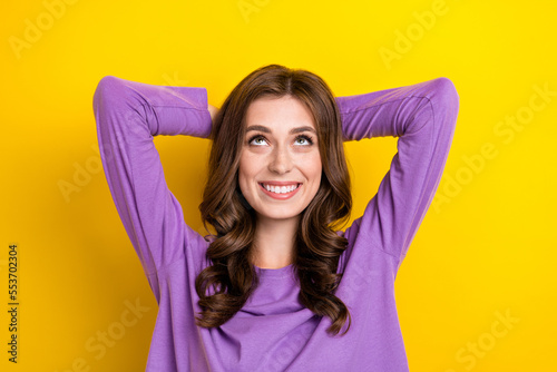 Photo of young toothy beaming smiling woman hands head nap looking up satisfied empty space dreaming idea isolated on yellow color background