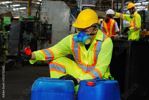 worker wearing uniform protection chemicals.Industrial worker holding plastic bottle with chemicals in factory.