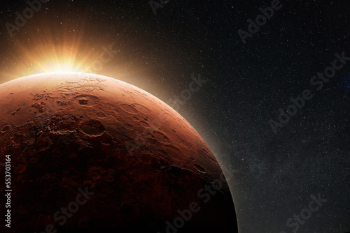 Amazing beautiful planet Mars with craters in stellar space with the sunrise light.