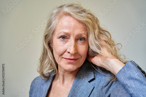 Senior blonde woman looking at the camera while holding her hair