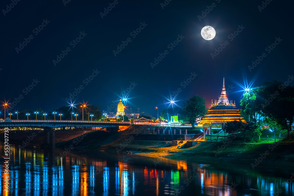 light on the Naresuan Bridge and Chedi of Wat Ratchaburana and Prang Wat Phra Si Rattana Mahathat also colloquially at the Nan River and the park and full moon at night in Phitsanulok,Thailand.