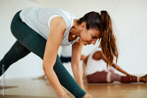 Smiling young woman doing yoga in a health club class photo