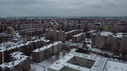 School and block apartment buildings in Kaunas, aerial ascend view. Winter photo