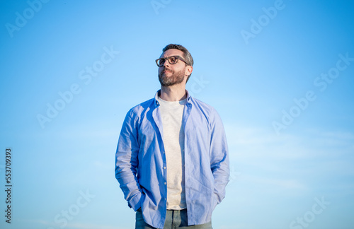 pensive caucasian man look peaceful. pensive man in glasses outdoor. pensive man on sky background.
