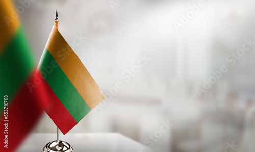 Small flags of the Lithuania on an abstract blurry background