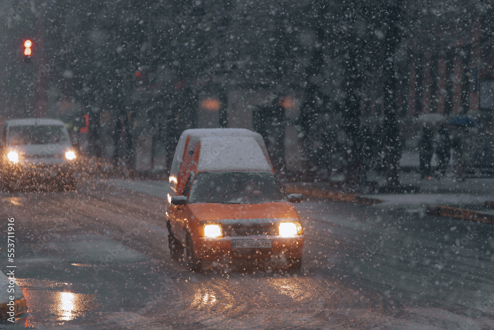 Winter driving. The movement of cars on the road in heavy snow. Snow storm in the city of Dnipro. Poor visibility during a snowstorm. Bad weather conditions on the road.