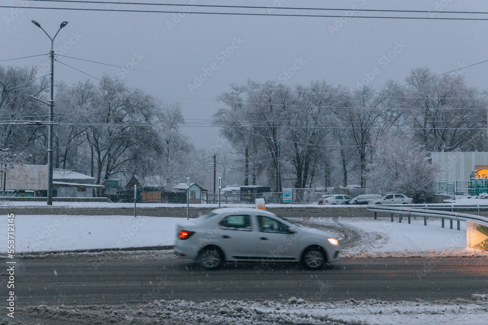 Winter driving. The movement of cars on the road in heavy snow. Snow storm in the city of Dnipro. Poor visibility during a snowstorm. Bad weather conditions on the road.