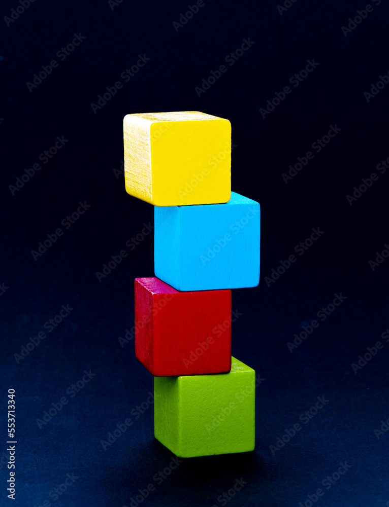 Obraz premium Wooden building blocks stacking on black background