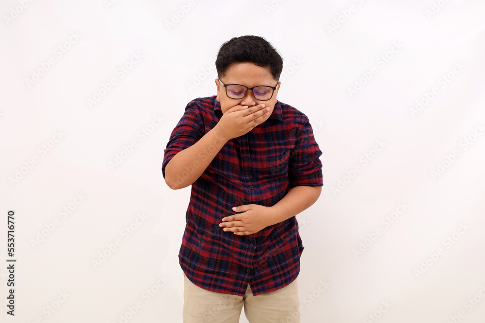 Asian boy standing holding her stomach and feeling nauseous and going to vomit. Isolated on white - obrazy, fototapety, plakaty 