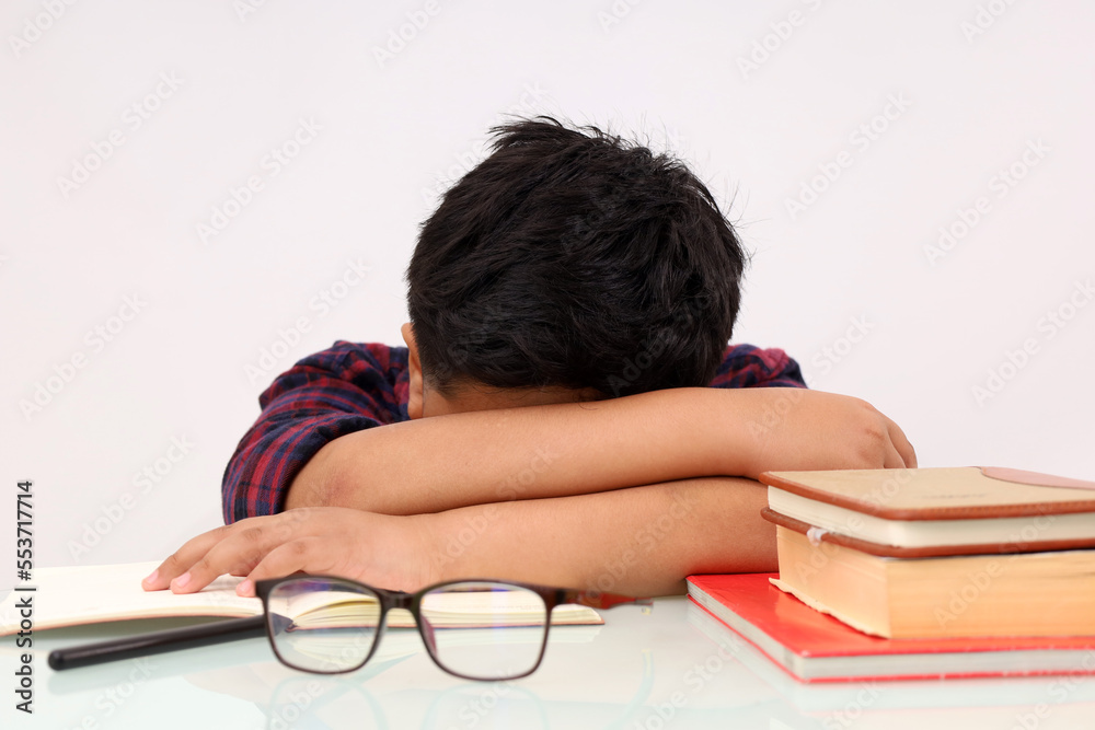 Tired asian school boy sleeping while studying. Isolated on white background Tired asian school boy sleeping while studying. Isolated on white background