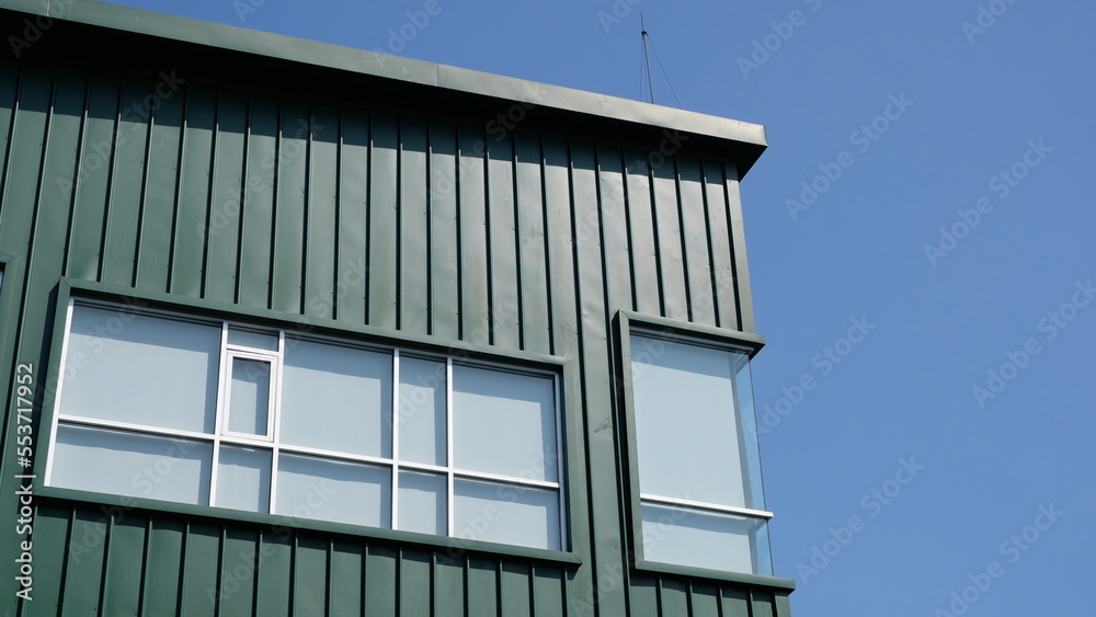 Obraz premium Rectangular windows on green building facade