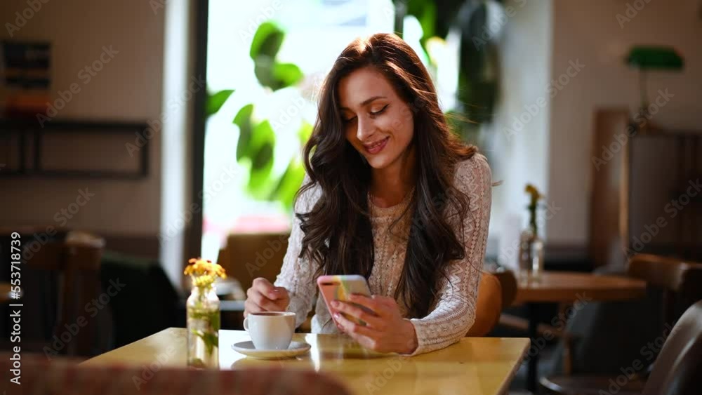 Beautiful woman relaxing with cup of coffee while using a smartphone in a cafe
Beautiful woman relaxing with cup of coffee while using a smartphone in a cafe