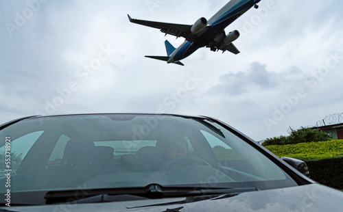 An airplane flying over the car