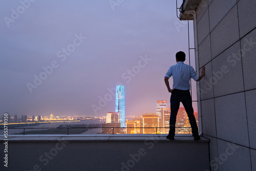 Businessman standing on the rooftop and looking away © xy