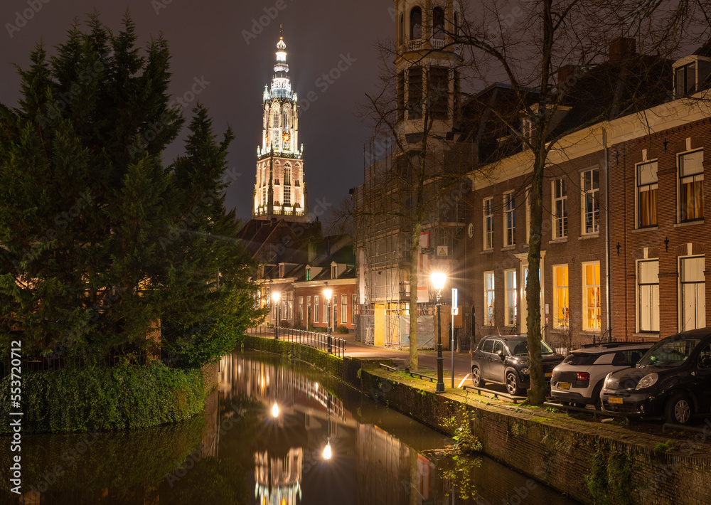 Cityscape of Amersfoort at night, view of the canal and the gothic church The Tower of Our Lady