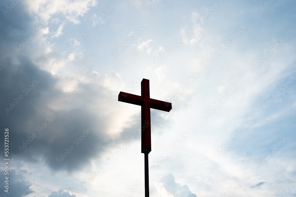 A christian cross under cloudy sky