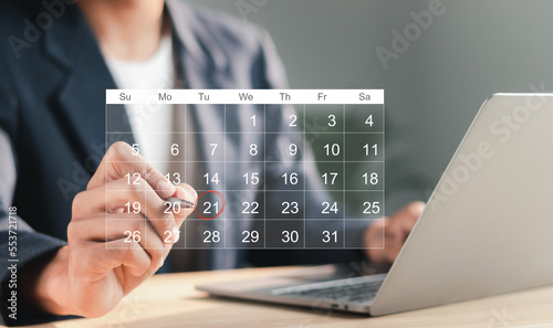  Businessman manages time for effective work. Calendar on the virtual screen interface. Highlight appointment reminders and meeting agenda on the calendar. Time management concept. photo