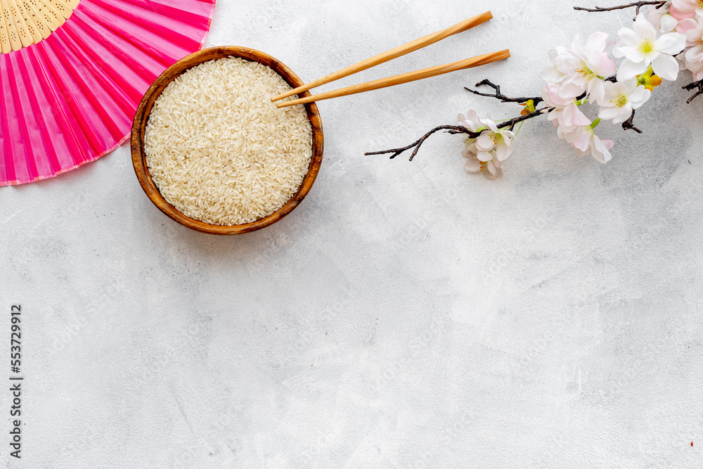 Bowl of rice and asian fan with cherry blossom branch. Asian concept