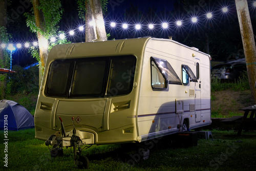 Travel Trailer Caravaning. RV Park Camping at Night. vacations, weekend, road trip, European mobile home on a camping site at night