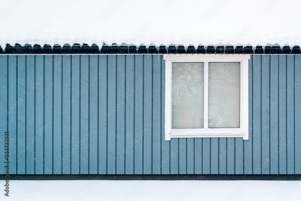 Single window on a blue exterior wall of a wooden building